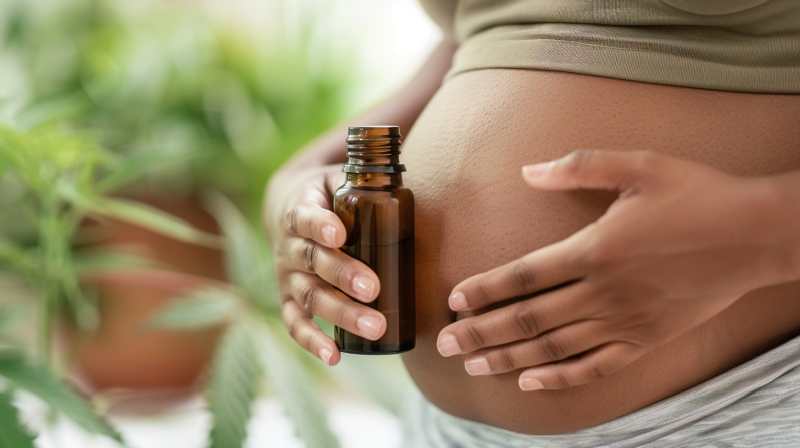 femme enceinte tenant un flacon de cbd devant son ventre bombé